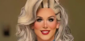 Portrait of a person with a platinum blonde voluminous wig, tiara, bold makeup, and red lipstick, smiling at the camera.